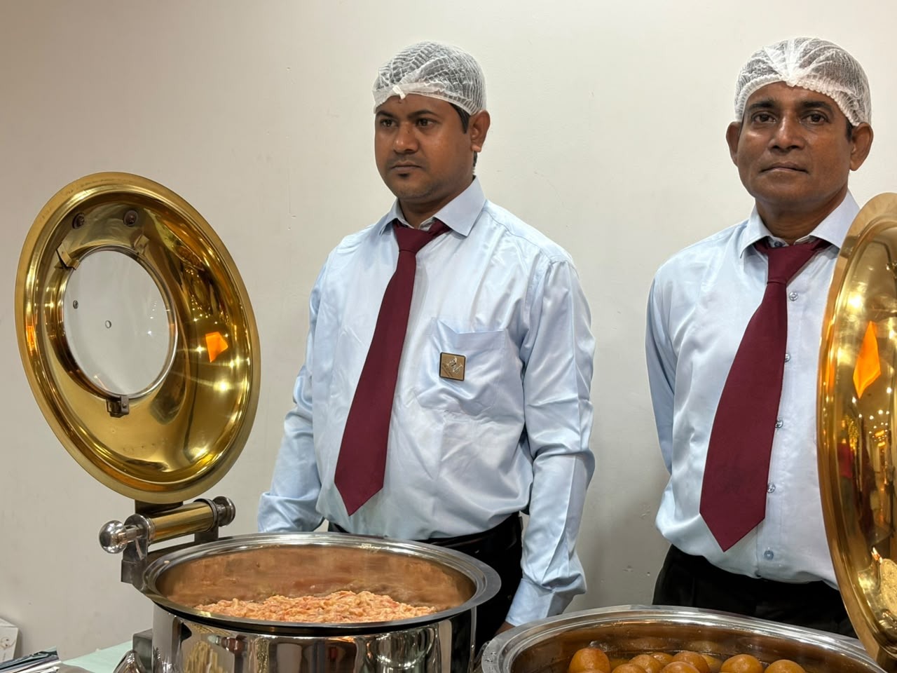Uniformed catering staff serving at a buffet