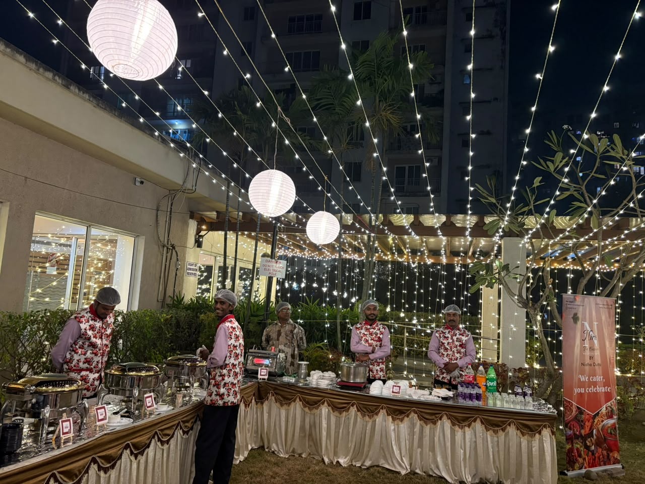 An evening buffet surrounded by flowers and festive lights